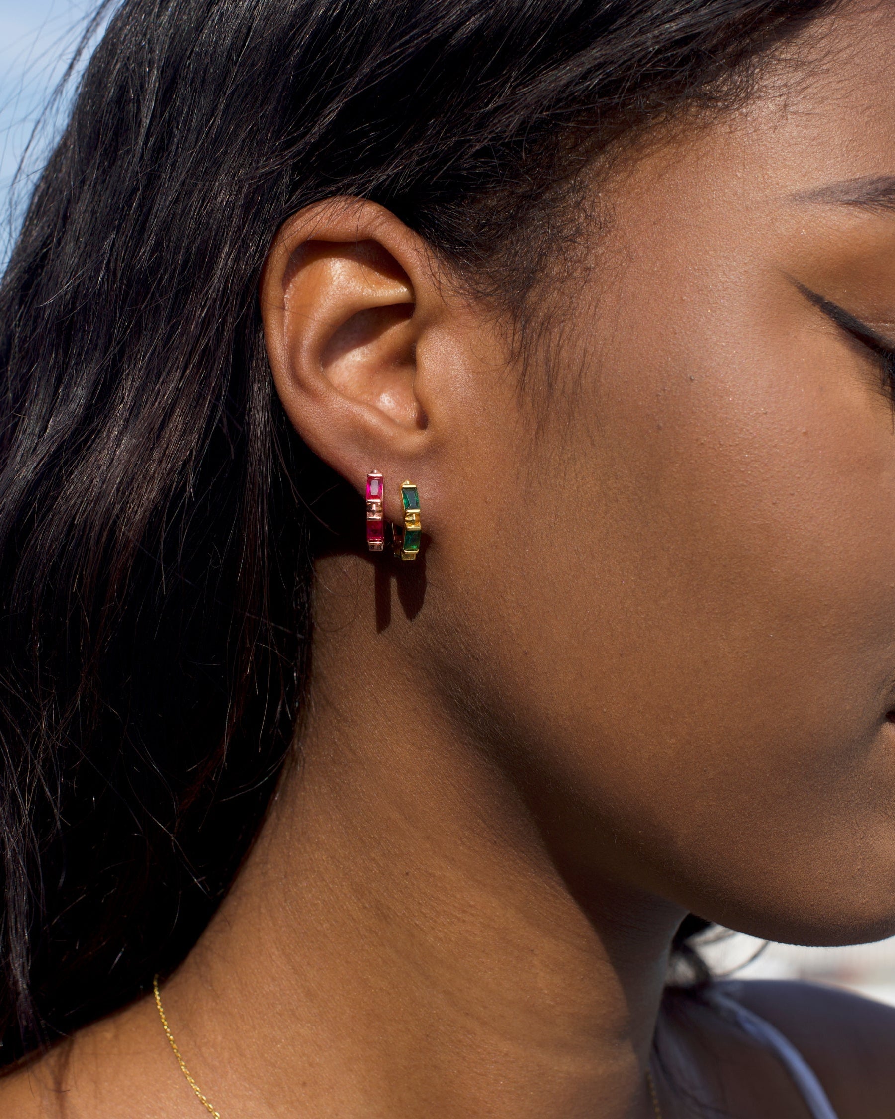 Detail of the emerald CZ stones on the Ora Ana Claire Huggie Hoops